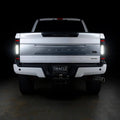Straight rear view of a white Ford Superduty with Flush Mount Tail Lights installed and reverse lights on.