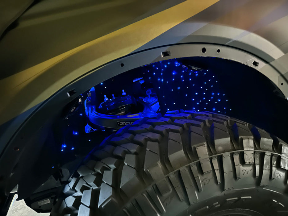 Close-up of fiber optic wheel liner kit installed on bronco with blue LED lighting