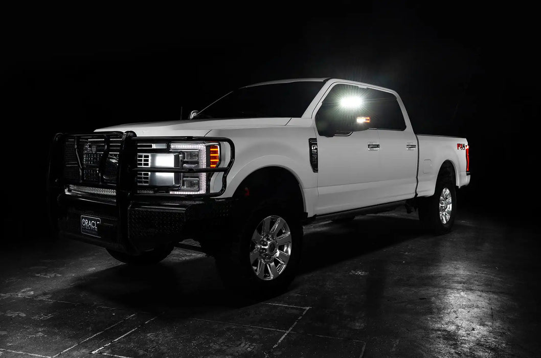 Three quarters view of a white Ford SuperDuty with LED Off-Road Side Mirrors turned on.