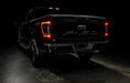 Rear three quarters view of black Ford F-150 with Flush Style LED Tail Lights installed and running lights on