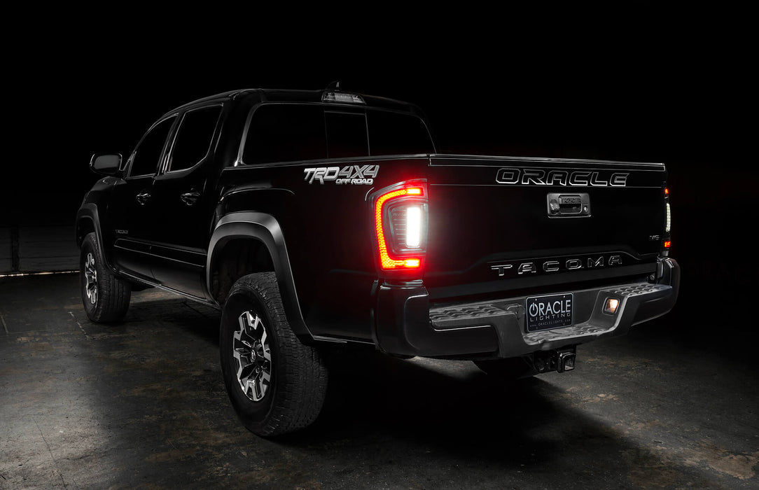 Rear three quarters view of black Toyota Tacoma with Flush Style LED Tail Lights installed and reverse lights on