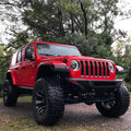 Three quarters view of a red Jeep Wrangler with Oculus Headlights installed.