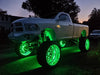 Front three quarters view of a white truck with green LED wheel rings installed.
