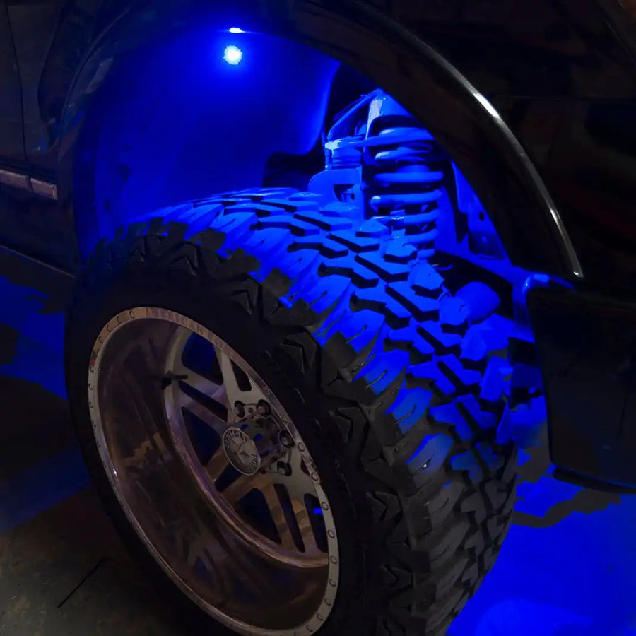 Close up of a wheel well with blue rock light glowing.