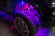 Close up of a wheel well with purple rock lights glowing.