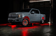 Grey Ford F-150 with red wheel rings and rock lights.