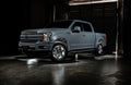 Grey Ford F-150 with white wheel rings and rock lights.