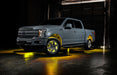 Grey Ford F-150 with yellow wheel rings and rock lights.