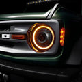 Close-up of a Ford Bronco grill with Oculus Headlights installed, and amber DRLs turned on.