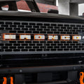 Close-up on the grill of a Ford Bronco with Amber LED Illuminated Letter Badges installed.