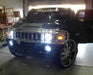 Front end of a Hummer H2 with white LED headlight and fog light halos.