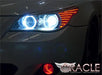 Close-up of white LED headlight halo rings installed on a BMW 5 Series.