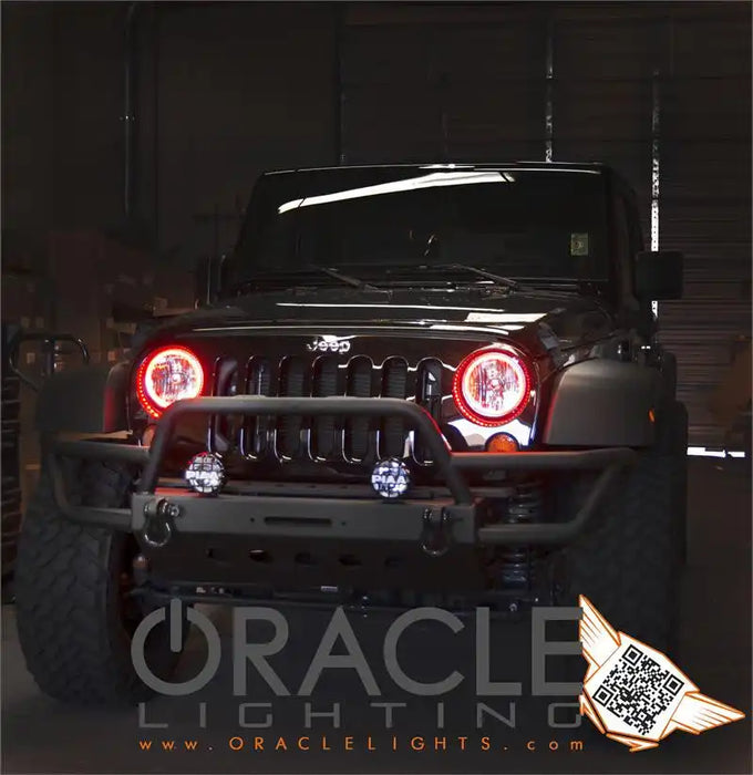 Front end of a Jeep Wrangler with red LED headlight halo rings installed.