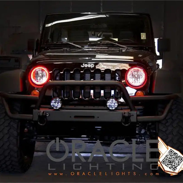 Front end of a Jeep Wrangler JK with red LED headlight halo rings installed.