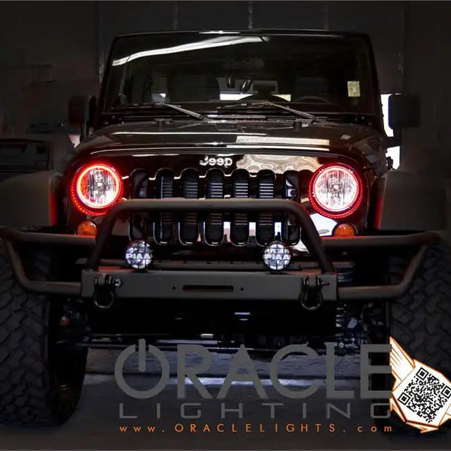 Front end of a Jeep Wrangler JK with red LED headlight halo rings installed.