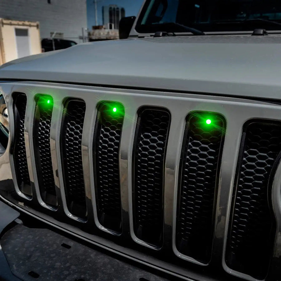 Front end of a Jeep Wrangler JL with green Pre-Runner Style LED Grill Light Kit installed.