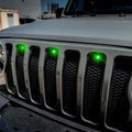 Close-up on the front end of a Jeep Wrangler with a green LED Grill Light Kit.