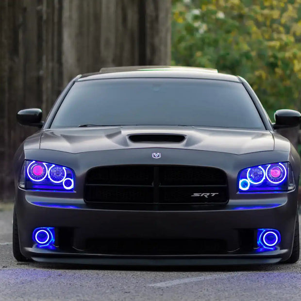 Black charger outside with blue headlight and fog light halos.