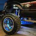 Close-up of a black truck's wheel well with rock lights and wheel rings installed.