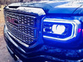 Close-up of a GMC Sierra headlight with blue DRLs.