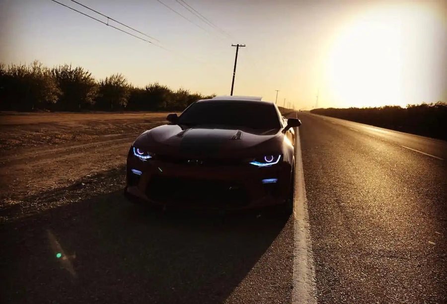 Camaro rolling outside with white DRLs and projector halos