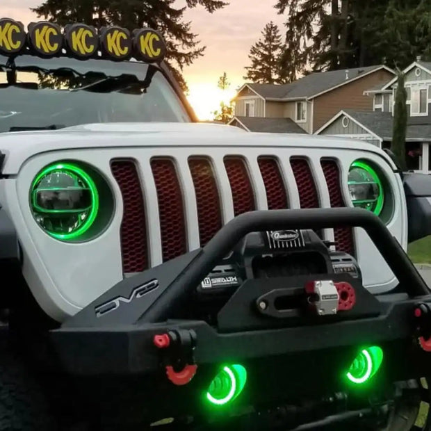Front end of a white Jeep Wrangler JL equipped with green headlight and fog light DRLs.
