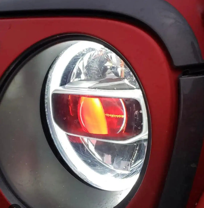 Close-up of a Jeep Headlight with red demon eye projector.