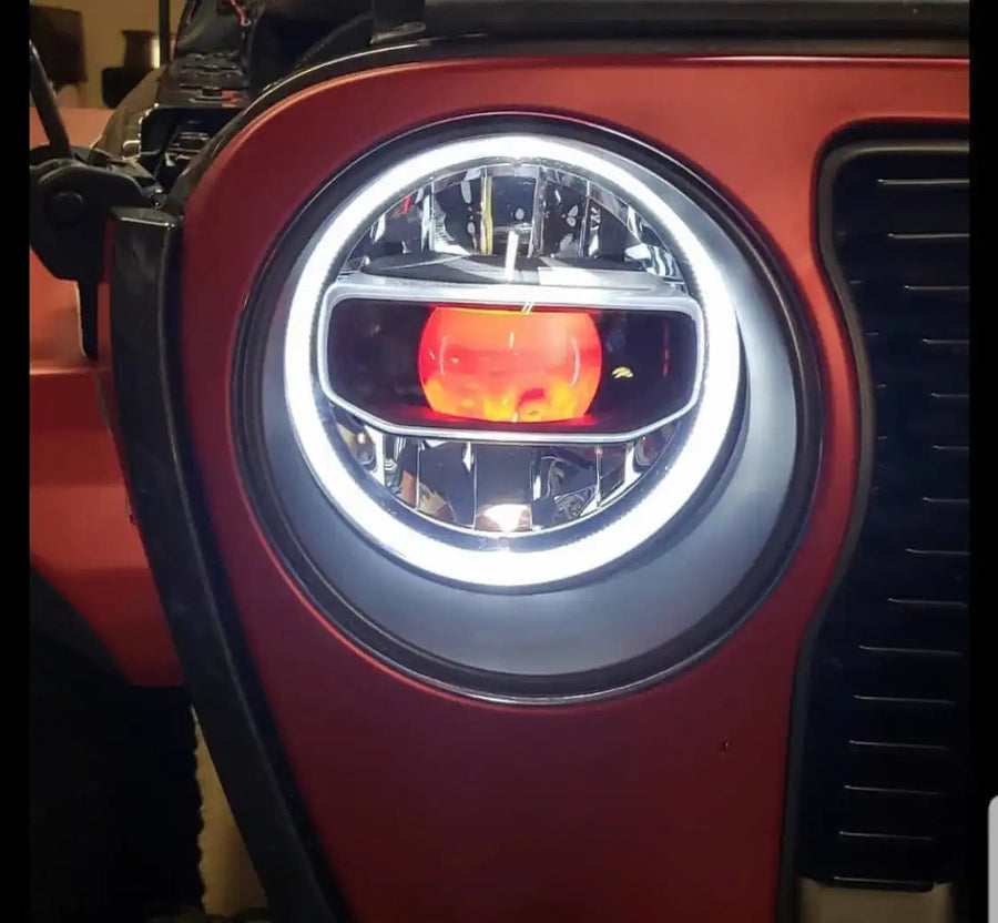 Close-up of jeep headlight with red demon eye projector