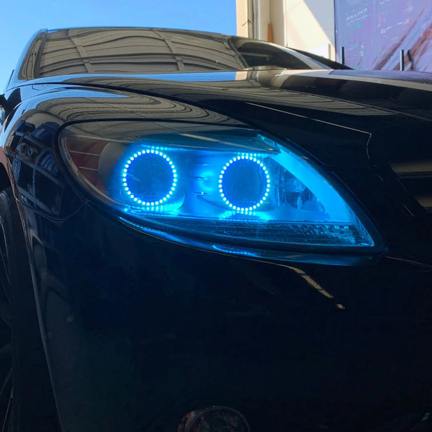 Close-up on the headlight of a Mercedes Benz CL 500 with cyan LED halo rings.