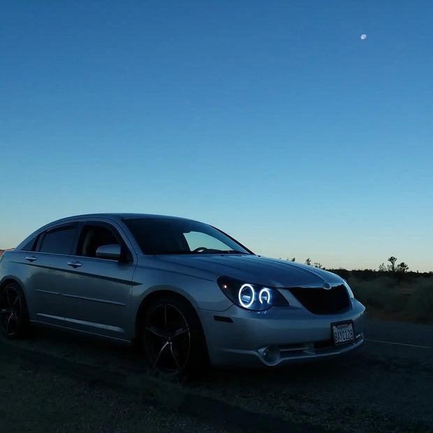 Three quarters view of a Chrysler Sebring with white LED headlight halo rings installed.
