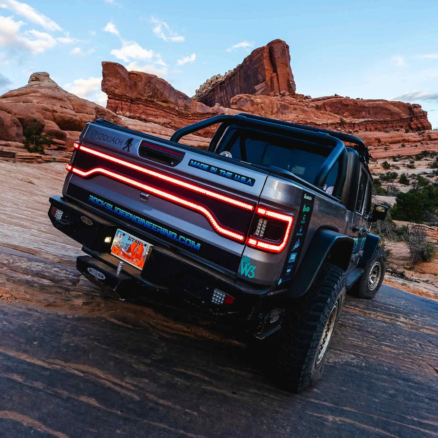Rear end of a Jeep Gladiator JT equipped with Flush Mount Tail Lights, High Powered Reverse Lights, and Racetrack LED Tailgate Panel.