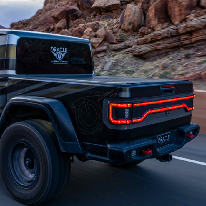 Jeep Gladiator JT driving down the desert highway, with Flush Mount Tail Lights and Racetrack LED Tailgate Panel glowing.