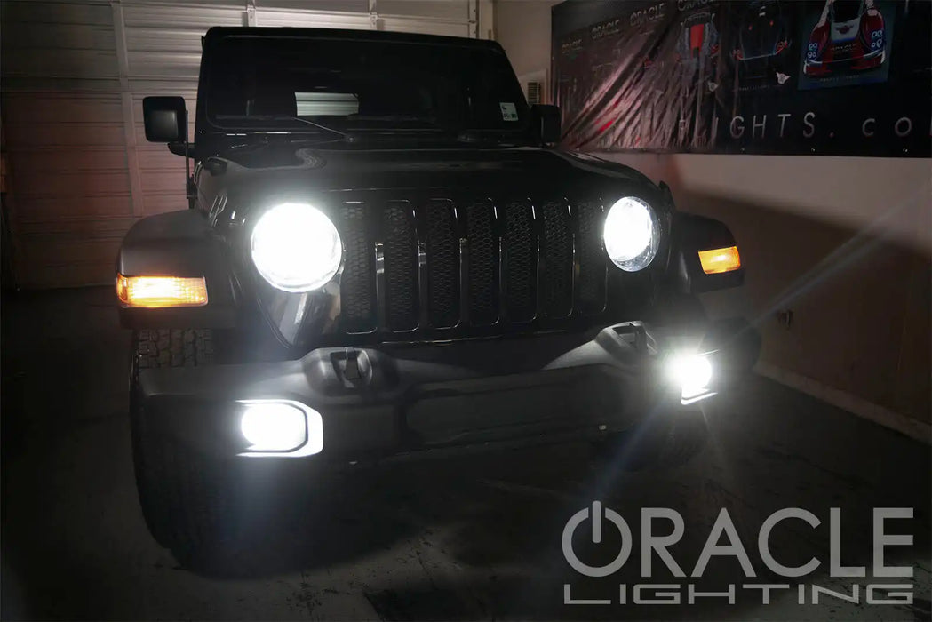 Black Jeep in a garage with bright LED headlights and fog lights