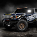 Three quarters view of ORACLE Lighting wrapped Ford Bronco with Integrated Windshield Roof LED Light Bar System installed and set to amber LEDs.