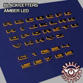 Amber LED Illuminated Letter Badges with Matte Black finish.