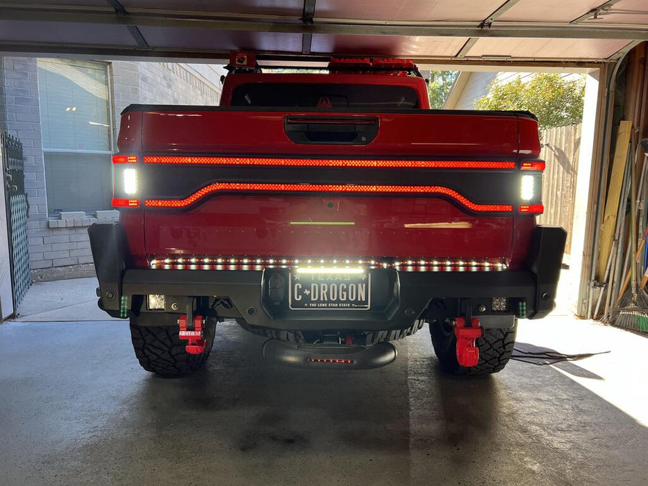 Red Jeep Gladiator in a garage with Racetrack Flush Style LED Tailgate Panel Light installed and reverse lights on.