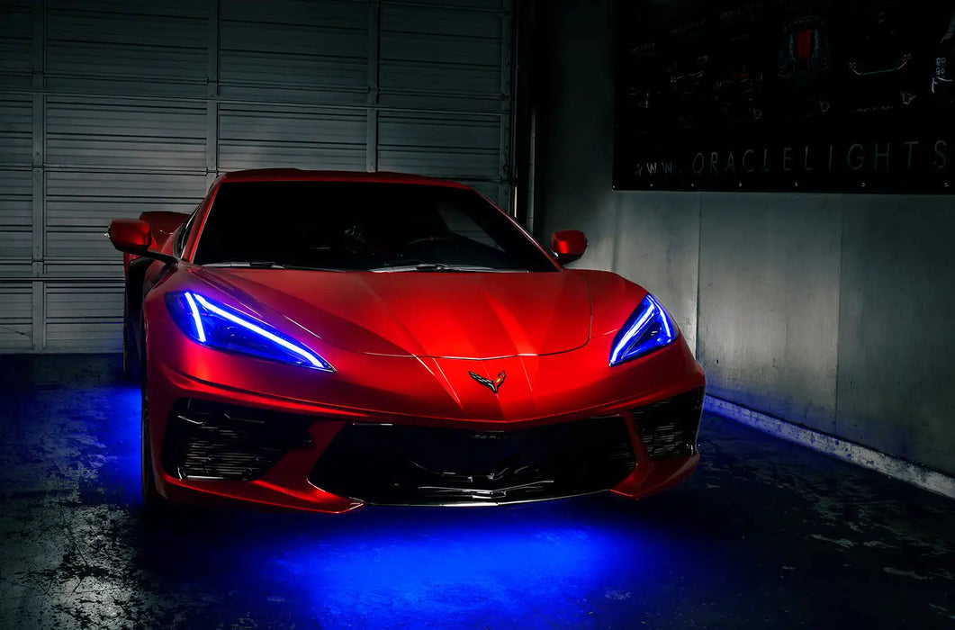 Red Corvette in a garage with blue headlight DRLs.