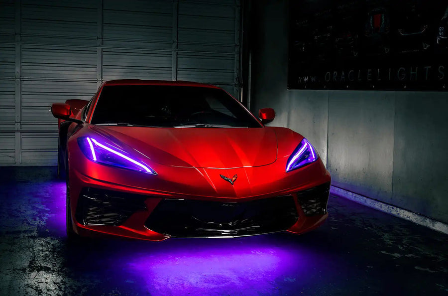 Red Corvette in a garage with purple headlight DRLs.