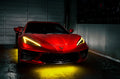 Red Corvette in a garage with yellow headlight DRLs.