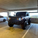 Two Ford Broncos on a rooftop parking lot, both equipped with Oculus Headlights.
