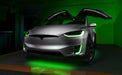 Silver Tesla Model X with green headlight and fog light DRLs.