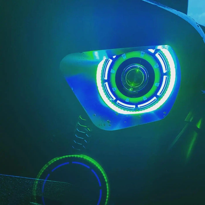Close-up of an Oculus Headlight installed on a Jeep, with green outer halo ring, and blue inner halo ring.
