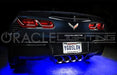 Rear view of a black Corvette with blue LED underbody kit.