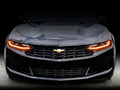 Front end of a Chevrolet Camaro with amber headlight DRLs.