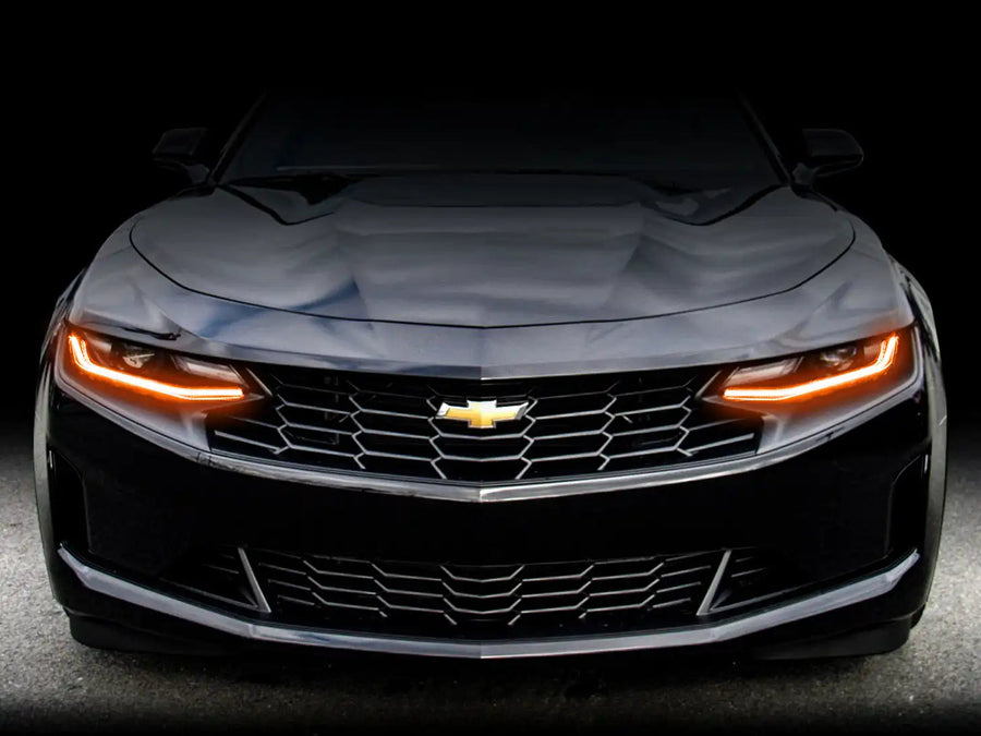 Front end of a Chevrolet Camaro with amber headlight DRLs.