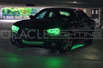 Front three quarters view of a black Charger with green LED halos and green LED underbody kit.
