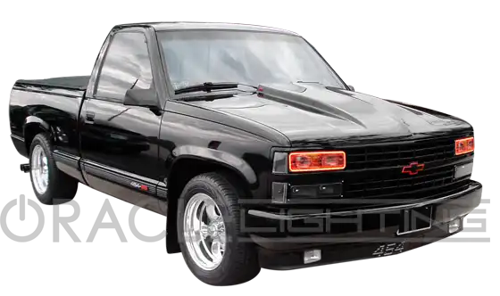 Three quarters view of a black truck with red LED headlight halos.