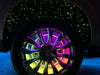 Close-up of a wheel well with Fiber Optic Starliner Kit and LED wheel rings installed, rainbow LEDs shining.