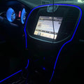 The console of a car, outlined with a blue LED fiber optic kit.