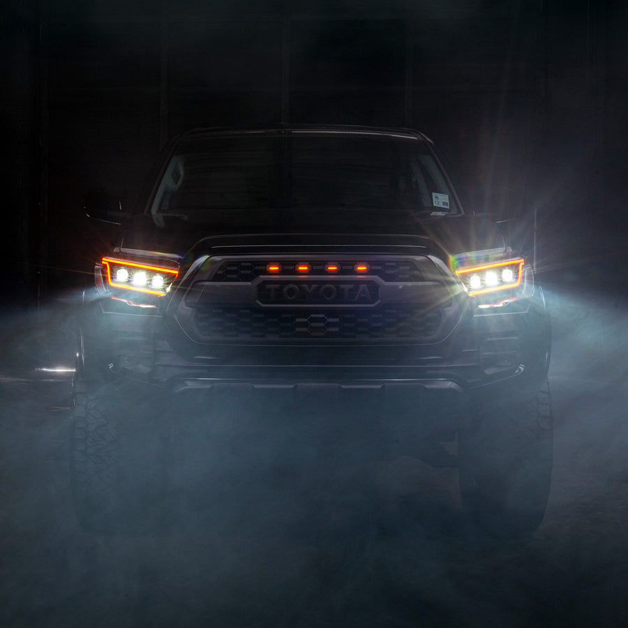 Front view of a Toyota truck in a dark, foggy environment